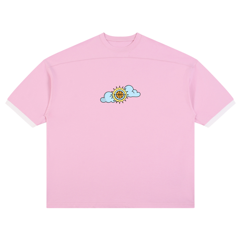 A light pink short-sleeve t-shirt with a small graphic on the center chest showing a yellow sun with a basketball inside, partially obscured by two light blue clouds. The t-shirt is displayed flat against a solid white background.