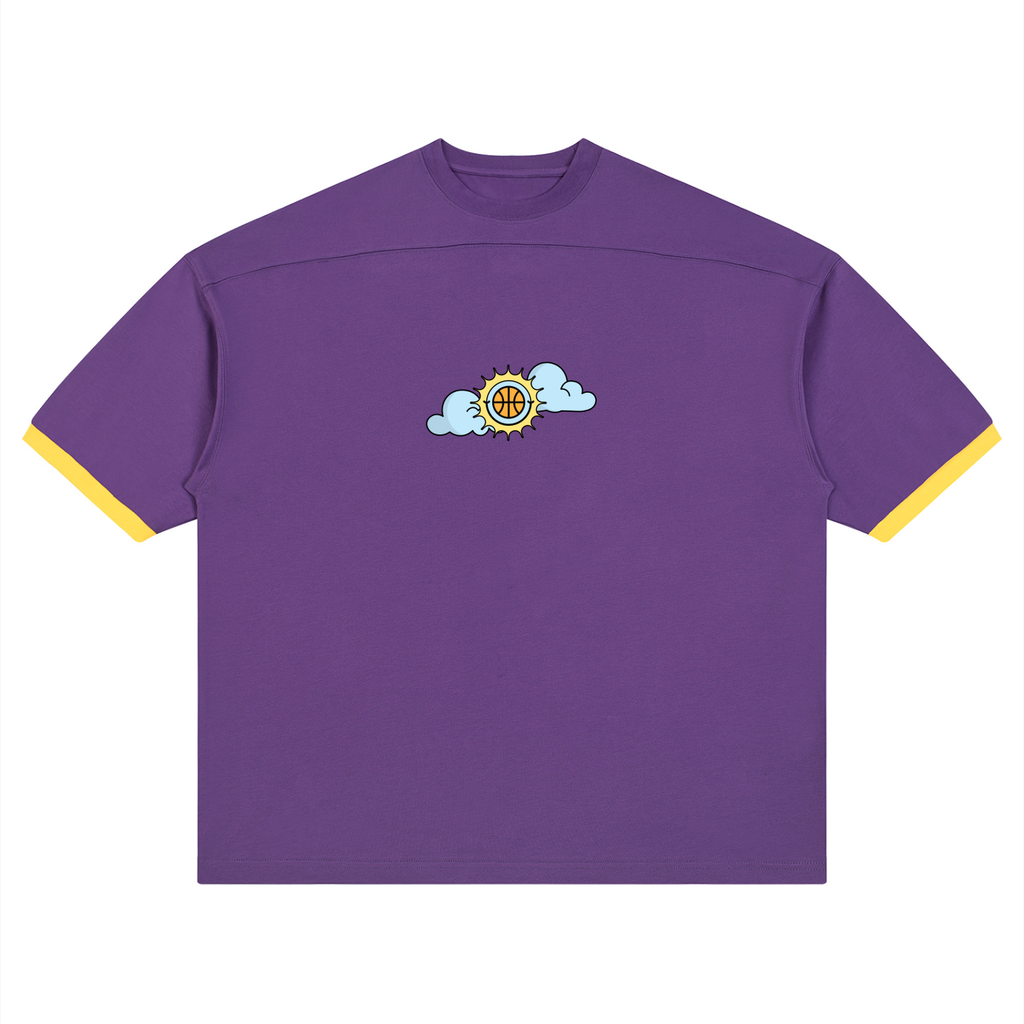 A purple short-sleeve t-shirt with yellow contrast trim on the sleeve cuffs and collar, featuring a small graphic of a basketball cloud logo on the center chest.