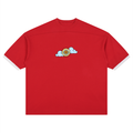 A red short-sleeve t-shirt with white contrast trim on the sleeve cuffs and collar, featuring a small cartoon graphic of a yellow basketball with a sun and light blue clouds on the center chest.